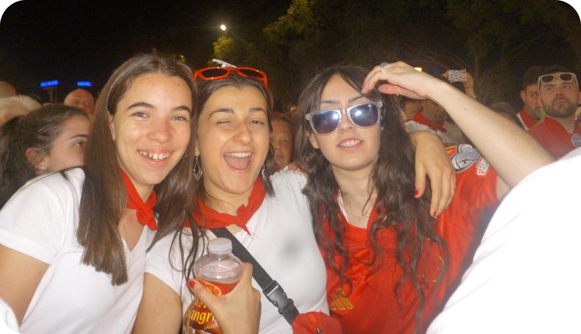 Fotografia de tres personas de fiesta vestidas de blanco y rojo