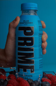 foto de botella prime con fondo azul y frutos rojos